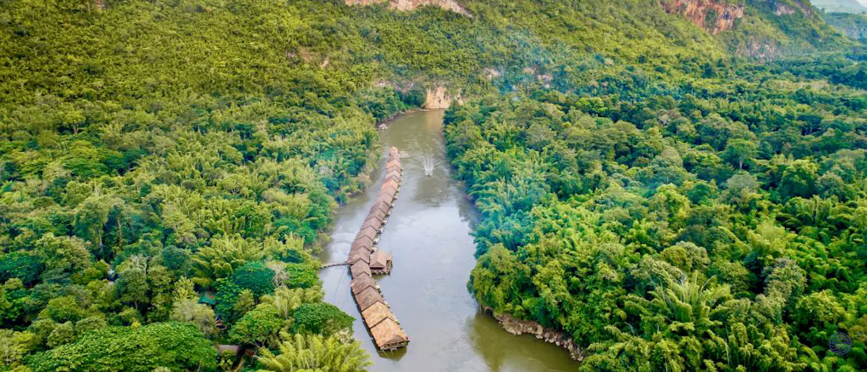 Charming floating bungalows on the River Kwai in Kanchanaburi, nestled within dense green jungle.