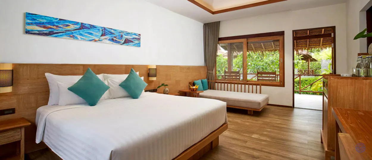 A luxurious resort room in Koh Phi Phi with a large bed and tropical garden view.