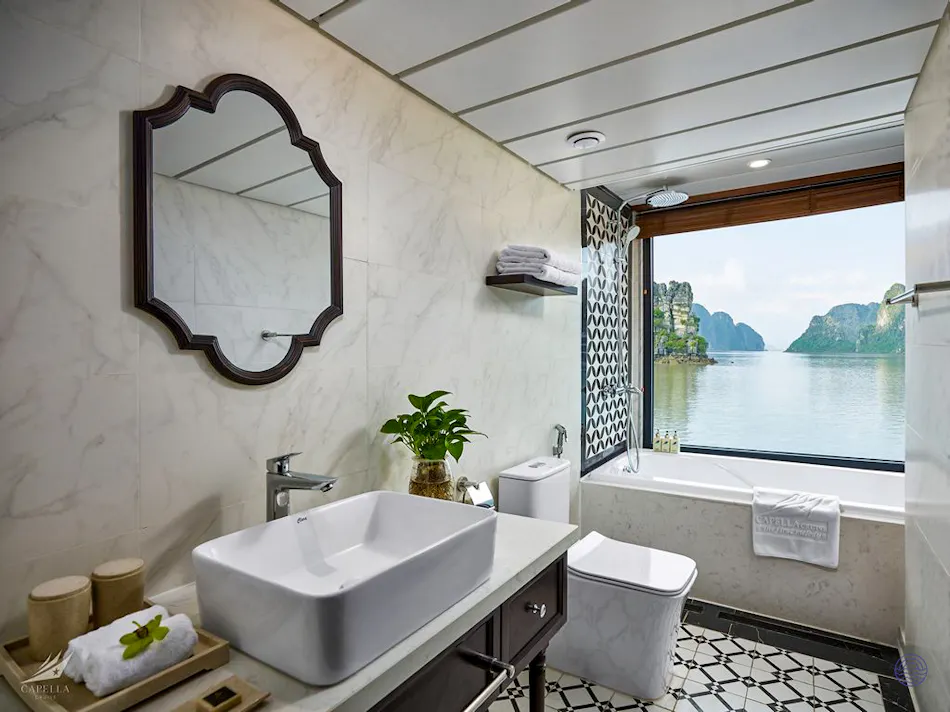 Elegant cruise bathroom featuring a large window with a breathtaking view of Ha Long Bay.