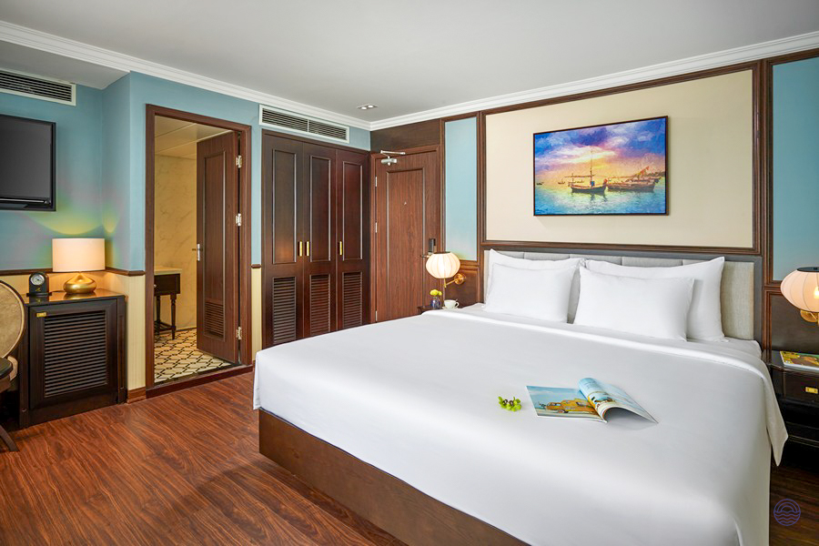 Comfortable Oasis Suite on the Capella Cruise, featuring a large bed and stylish decor in Halong Bay.