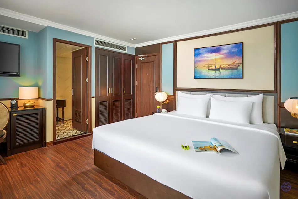 Inviting cruise cabin on Capella Cruise in Ha Long Bay, featuring a king bed and elegant wooden decor.