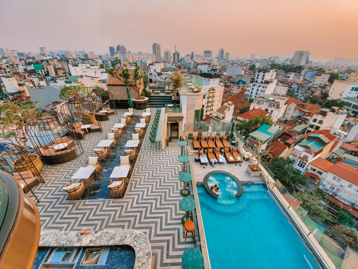 Guests enjoy the luxurious rooftop pool and bar at Peridot Grand Hotel with panoramic Hanoi city views.