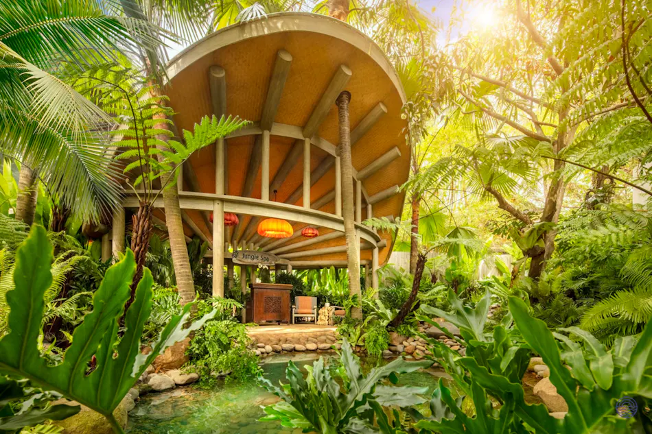 Elegant circular pavilion nestled in vibrant tropical gardens with a tranquil pond at An Lam Retreats.