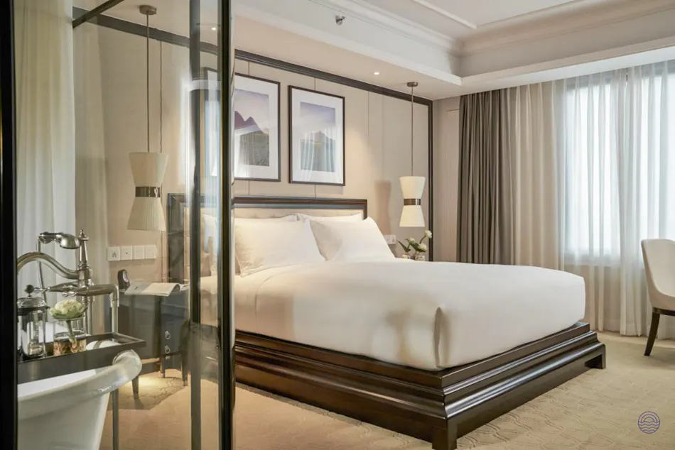 Elegant premium room at Mai House Saigon Hotel featuring a large bed and stylish lighting.