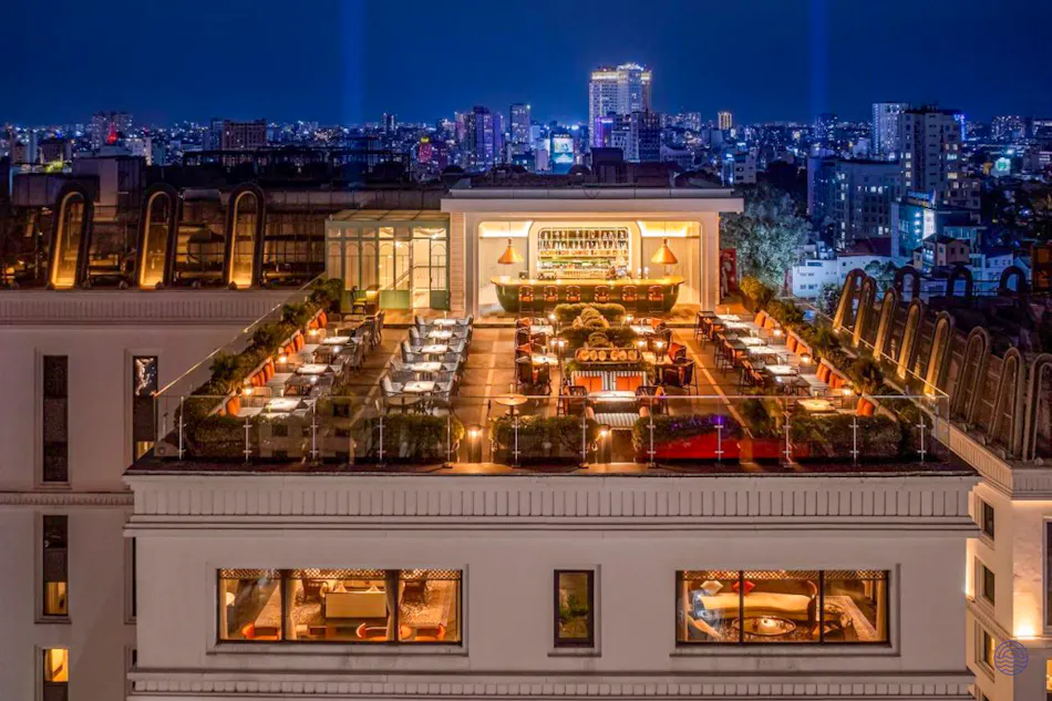 Sophisticated rooftop dining experience overlooking the illuminated Ho Chi Minh City skyline.
