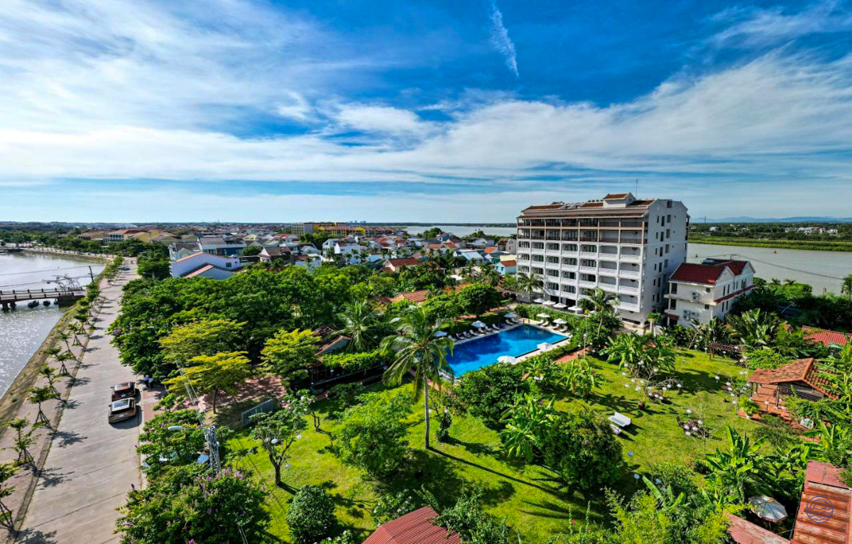 Riverside resort with a large swimming pool, green gardens, and a town view in Hoi An.