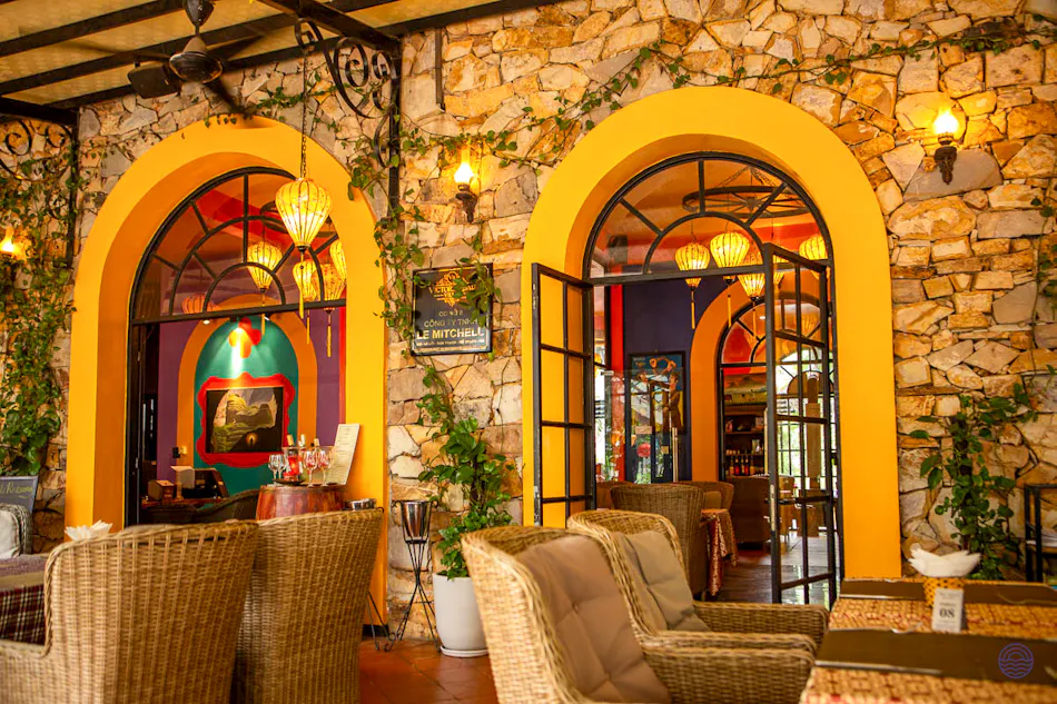 Charming outdoor lounge at Victory Villas in Phong Nha with stone walls and vibrant arched entrances.