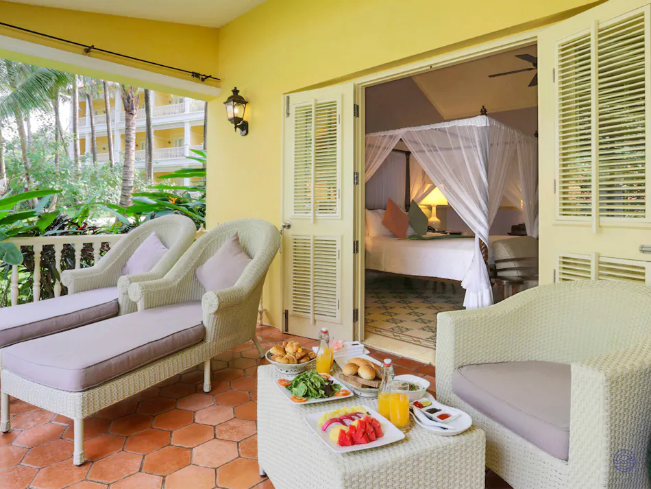 Sunny resort balcony in Phu Quoc with breakfast spread and a luxurious bedroom with a canopy bed.