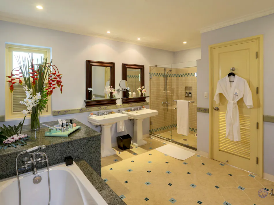 Elegant resort bathroom featuring a large bathtub, double sinks, and glass shower in Phu Quoc.