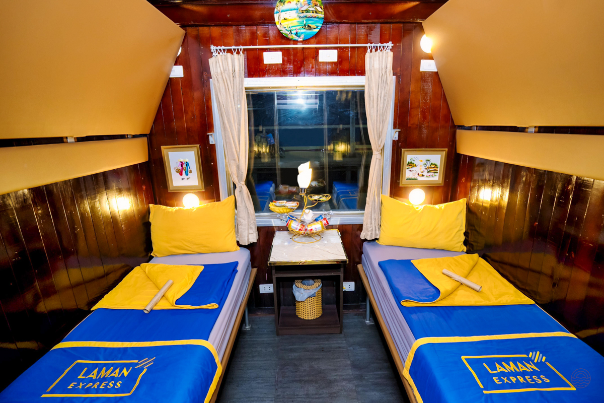A private overnight train cabin with two comfortable beds and warm lighting for travelers.
