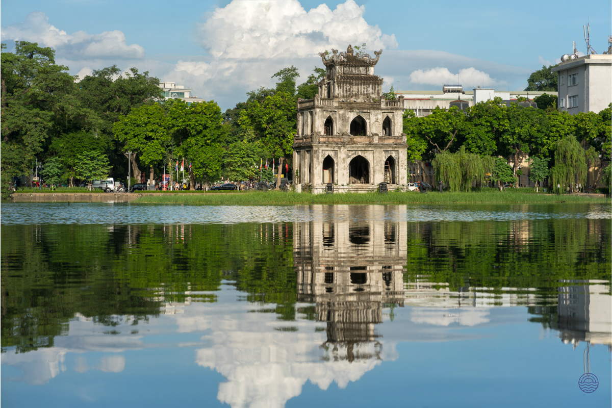 The historic Turtle Tower stands majestically on Hoan Kiem Lake, reflecting beautifully in Hanoi's calm waters.