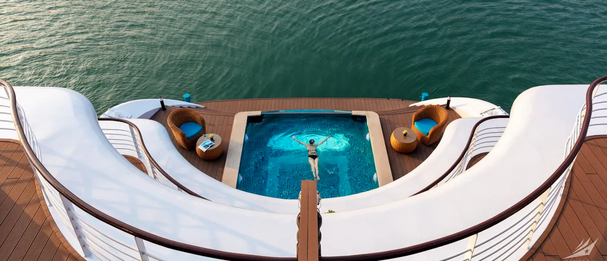 A person swims in a beautiful deck pool on a luxury cruise ship in Halong Bay.